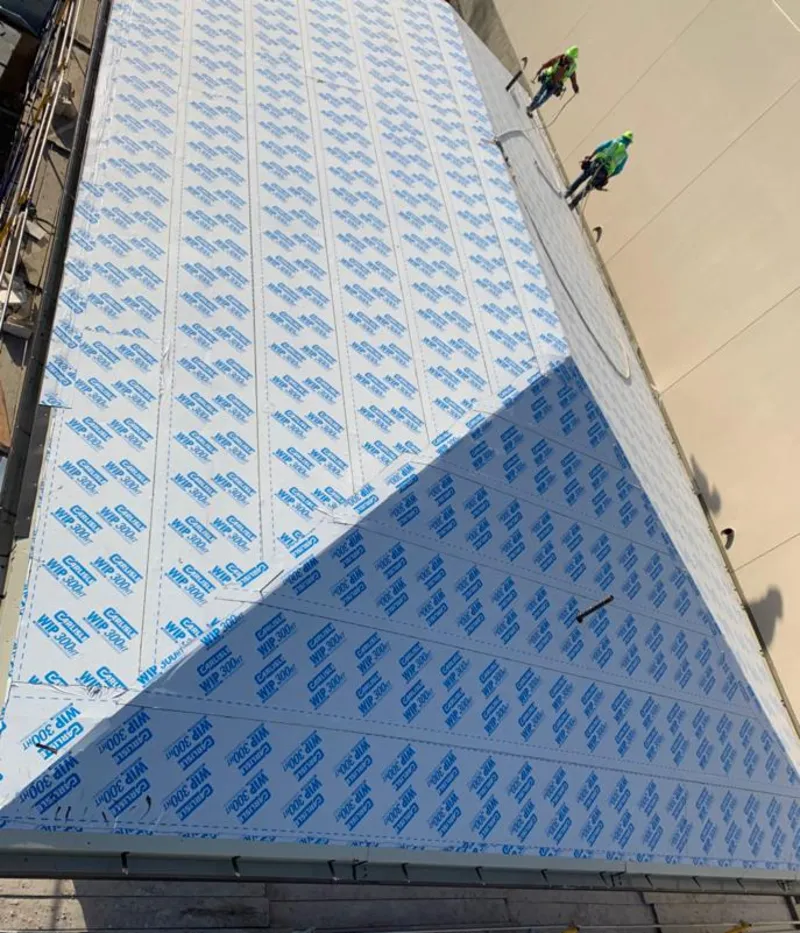 Professional roofers installing underlayment on a metal roof in Apple Valley